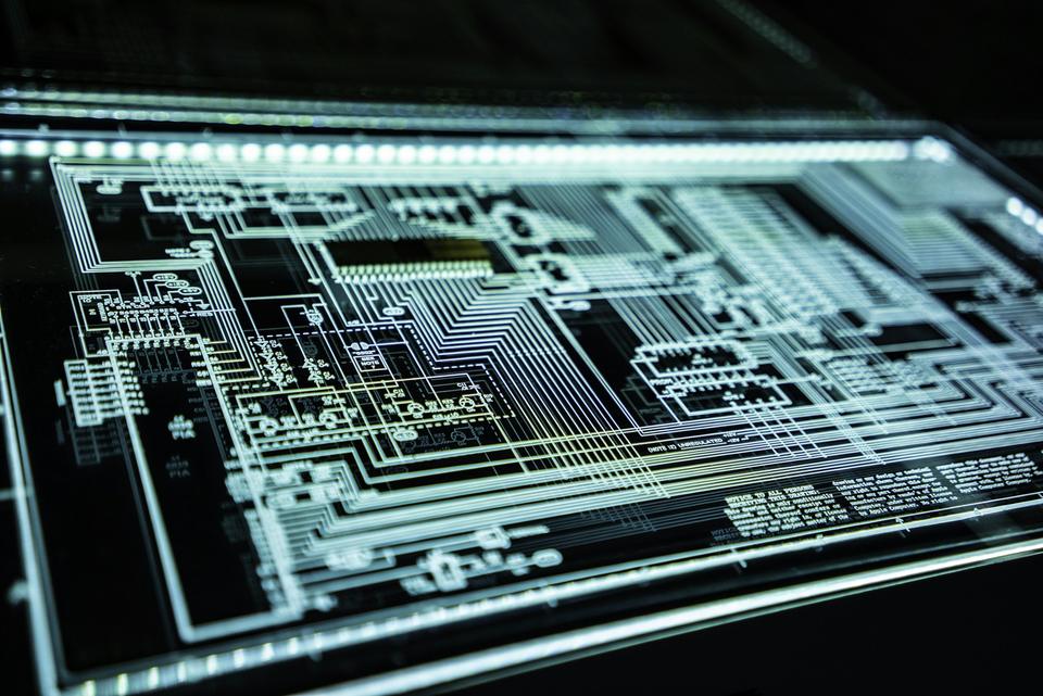 Close-up of a circuit board lit in teal
