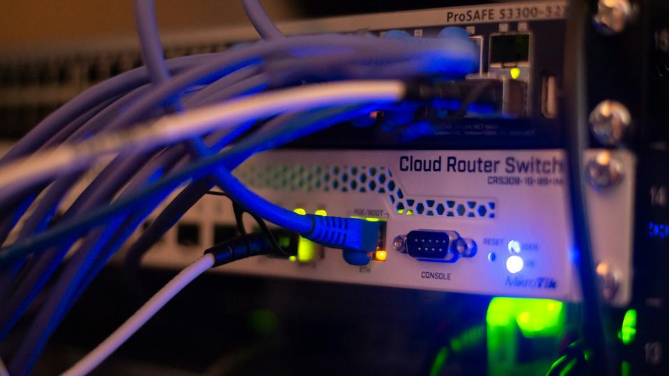 Blue patch cables plugged into a network switch with status lights