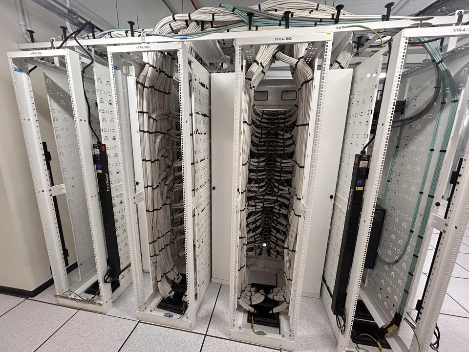 Overhead view along a row of open data centre racks with cable management